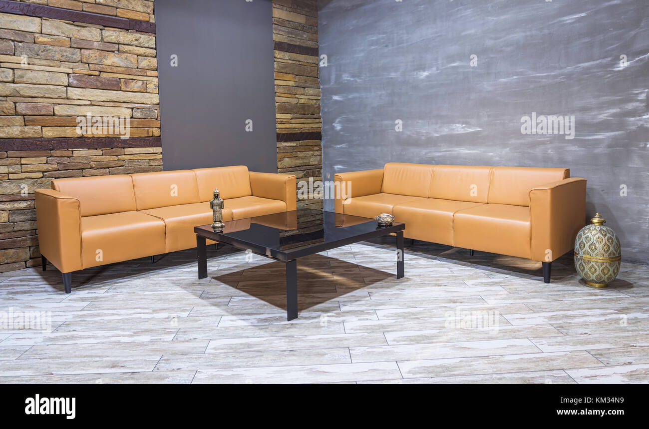 Vintage moderne ,intérieur salon canapé en cuir marron, blanc sur le parquet et mur de briques. Banque D'Images