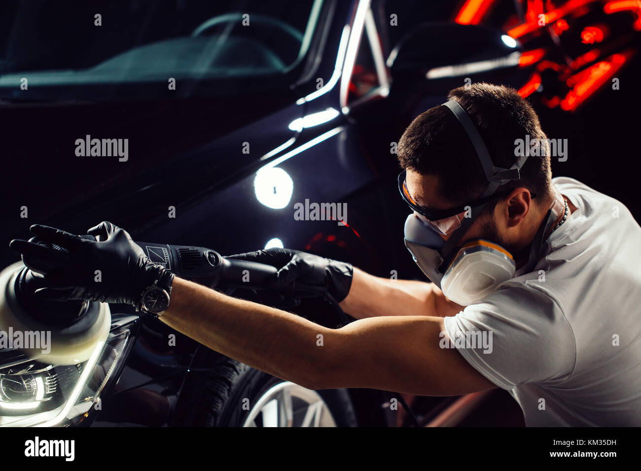 Esthétique auto - homme avec polisseuse orbitale en atelier de réparation automobile. focus sélectif. Banque D'Images