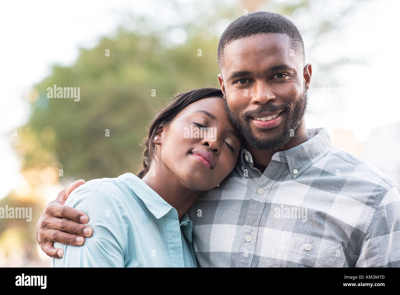 Happy young couple debout à l'extérieur par une journée ensoleillée Banque D'Images