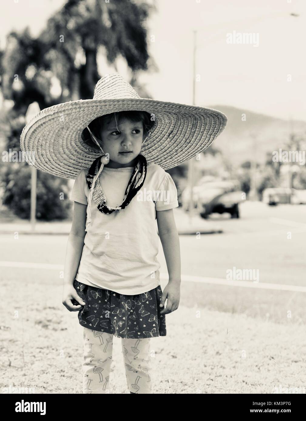 Jeune fille portant un sombrero marche dans une rue de banlieue, Townsville, Queensland, Australie Banque D'Images