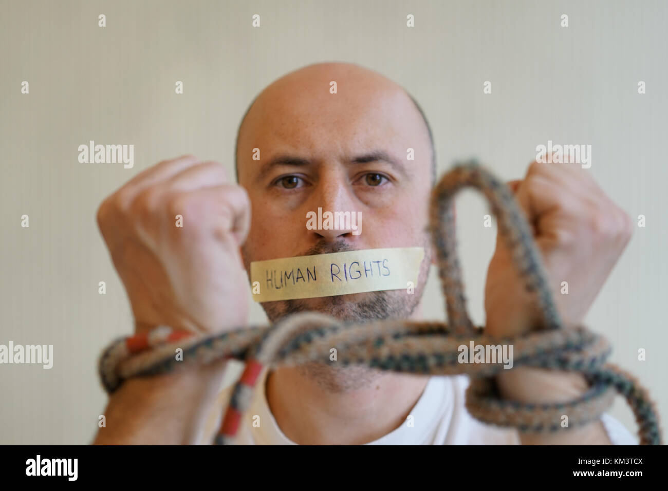 Homme avec les mains liées et une bouche scellée. La journée des droits de l'concept. Banque D'Images