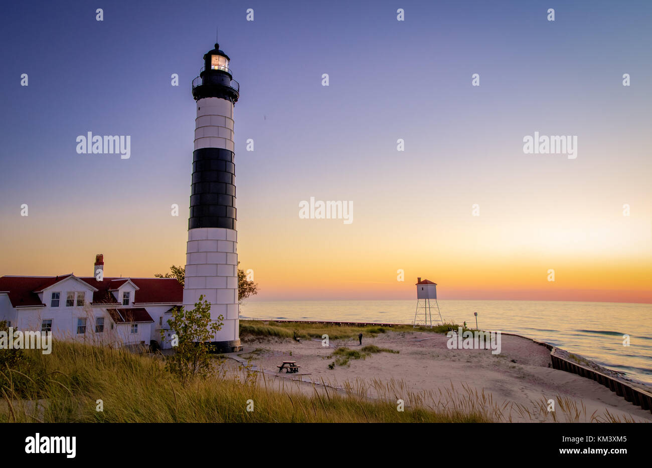 Lighthouse Beach fond Coucher de soleil. Grand phare lumineux sable brillant avec balise sur la rive sablonneuse du lac Michigan au coucher du soleil à Ludington. Banque D'Images