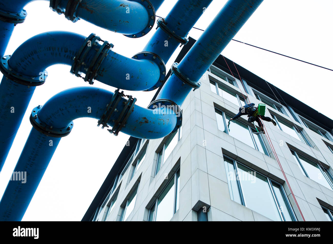 Le nettoyant pour vitres descend au-dessus de la structure de tuyau. Berlin. Allemagne. Banque D'Images