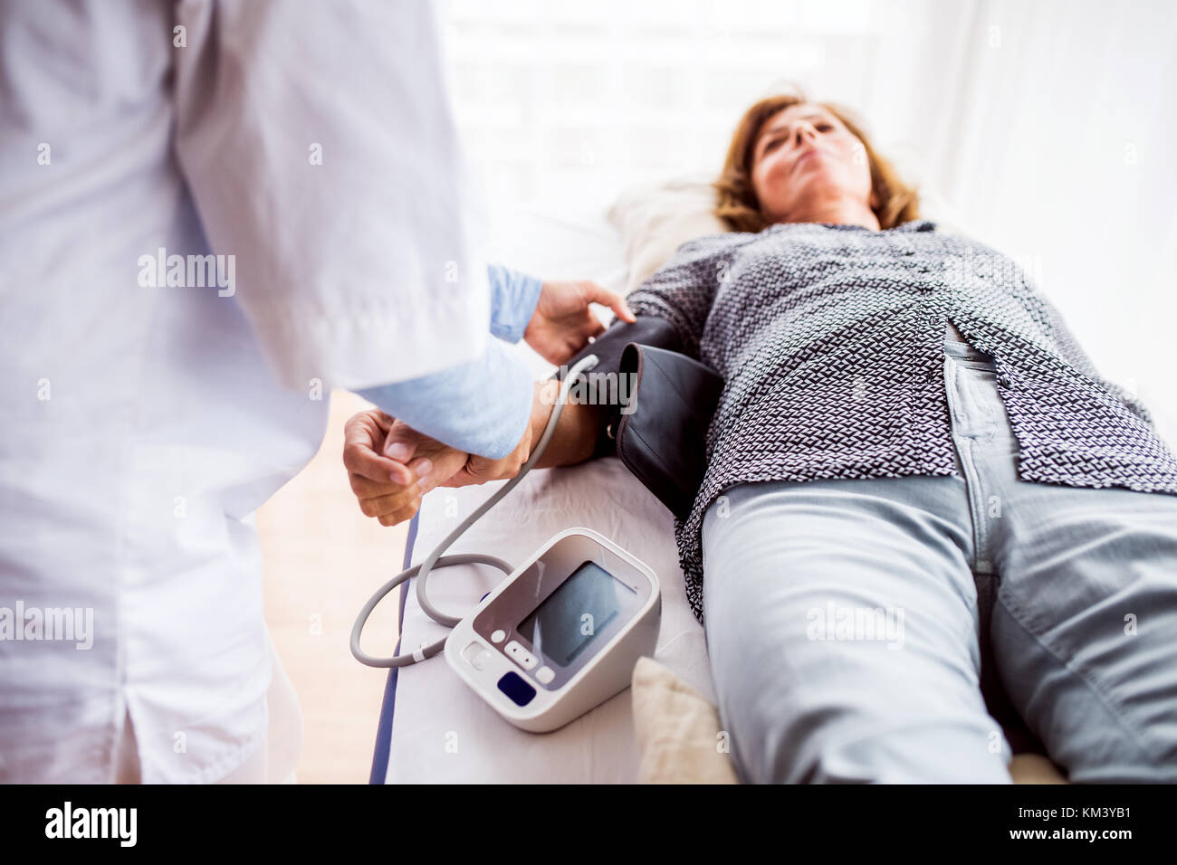 Femme médecin contrôle de la pression artérielle d'un senior femme. Banque D'Images