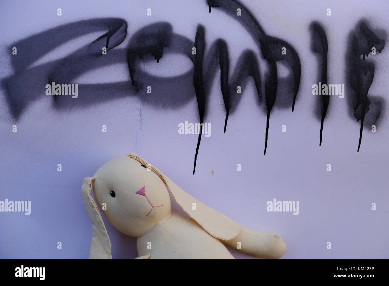 Lapin jouet sous un zombie poster d'avertissement. Banque D'Images