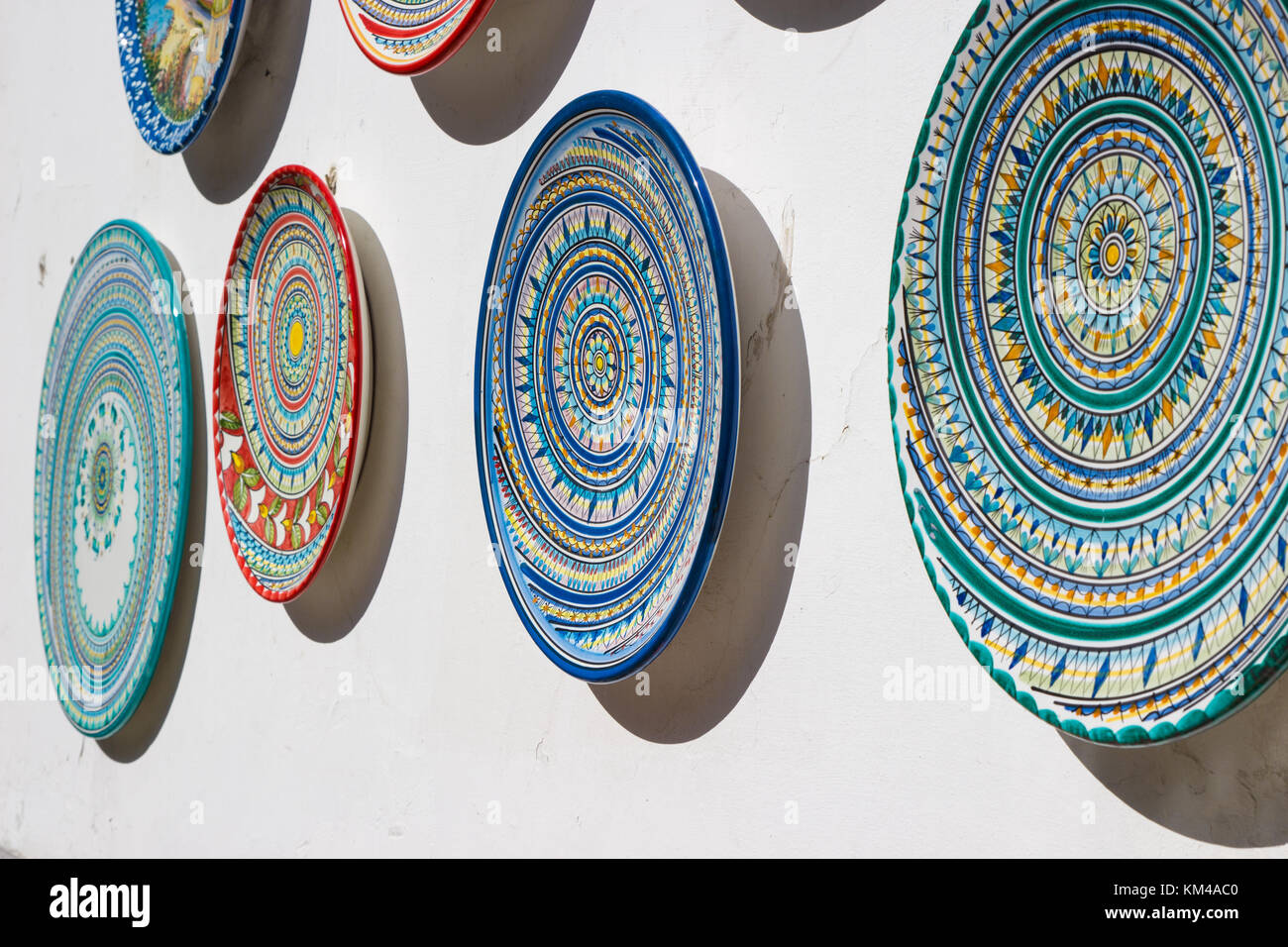 Divers plats poterie décorée hung à la vente en dehors d'un magasin de souvenirs sur la côte amalfitaine, en Italie. Banque D'Images