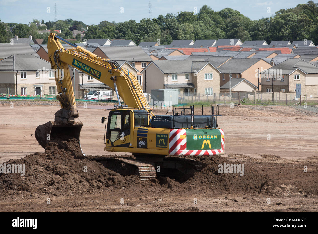 La construction de maisons sur une friche industrielle à Bishopton, Ecosse montrant de nouvelles maisons, terres défrichées et diggers préparer le terrain Banque D'Images