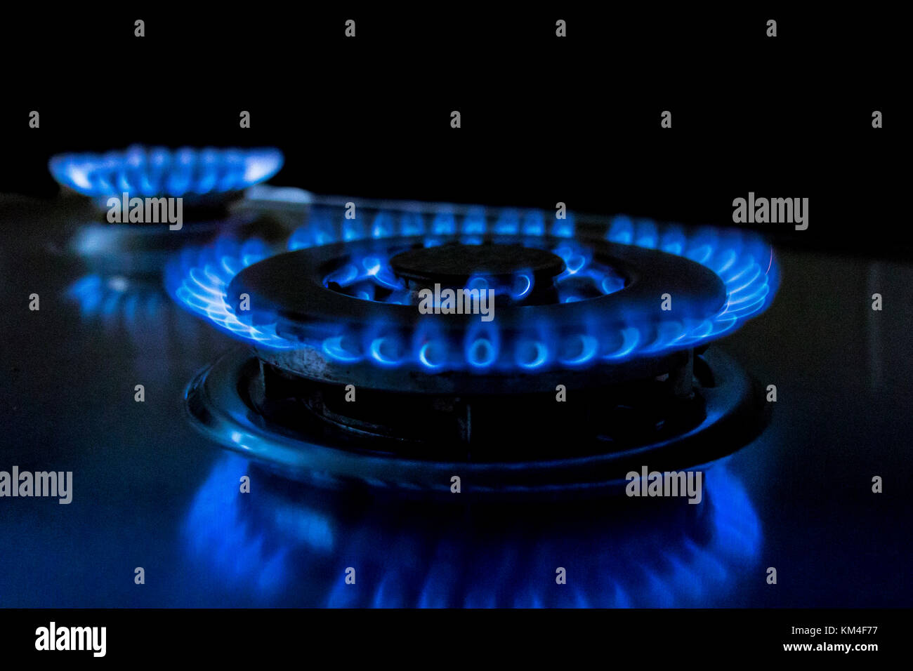 Gros plan d'une flamme bleue d'une table de cuisson à gaz sur une cuisinière à gaz Banque D'Images