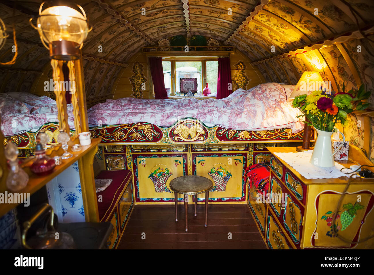 L'intérieur d'une roulotte traditionnelle avec lit double et placards, bow top roof et cuisinière. Banque D'Images