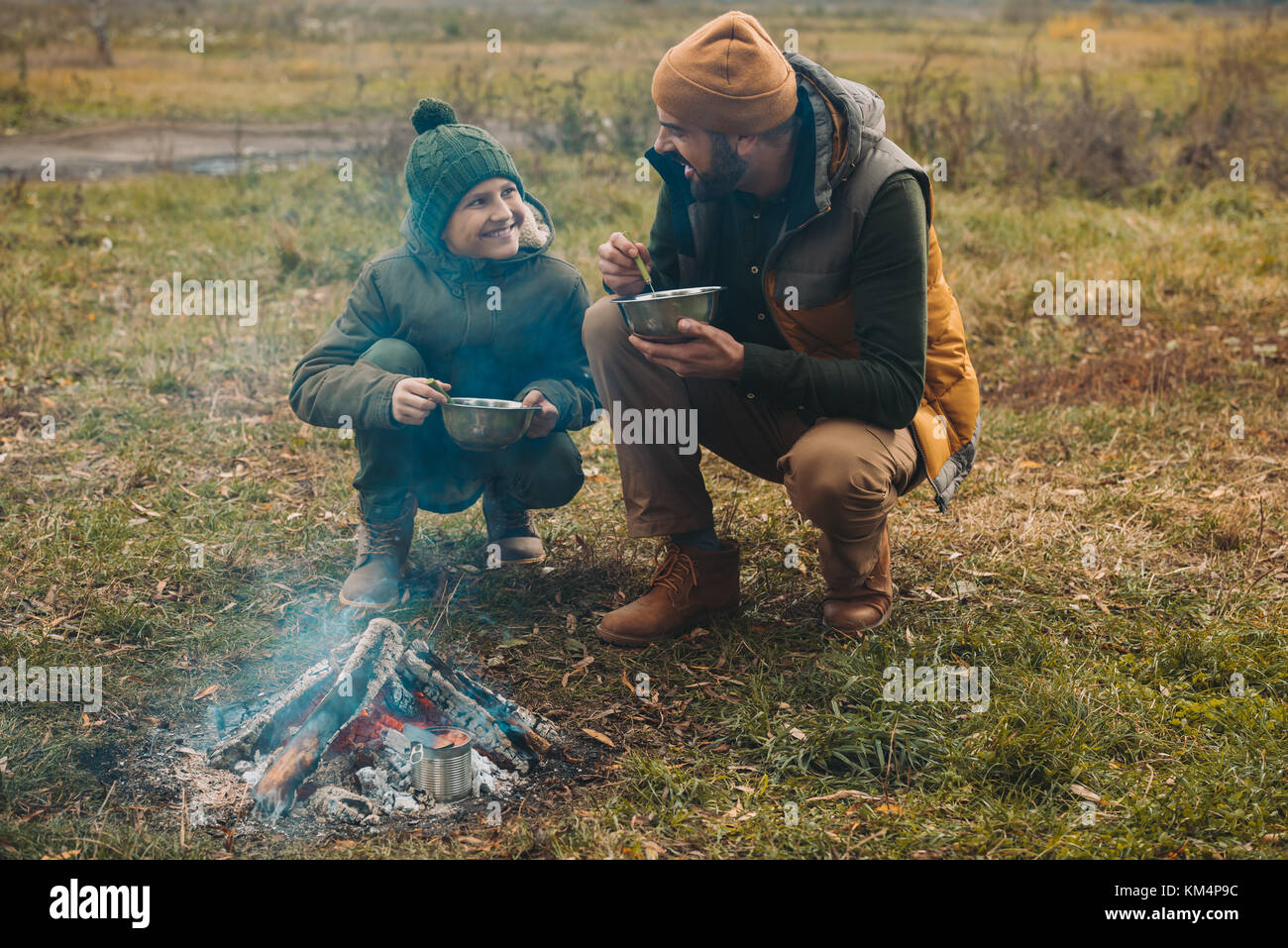 Père et fils de manger des aliments sur la nature Banque D'Images