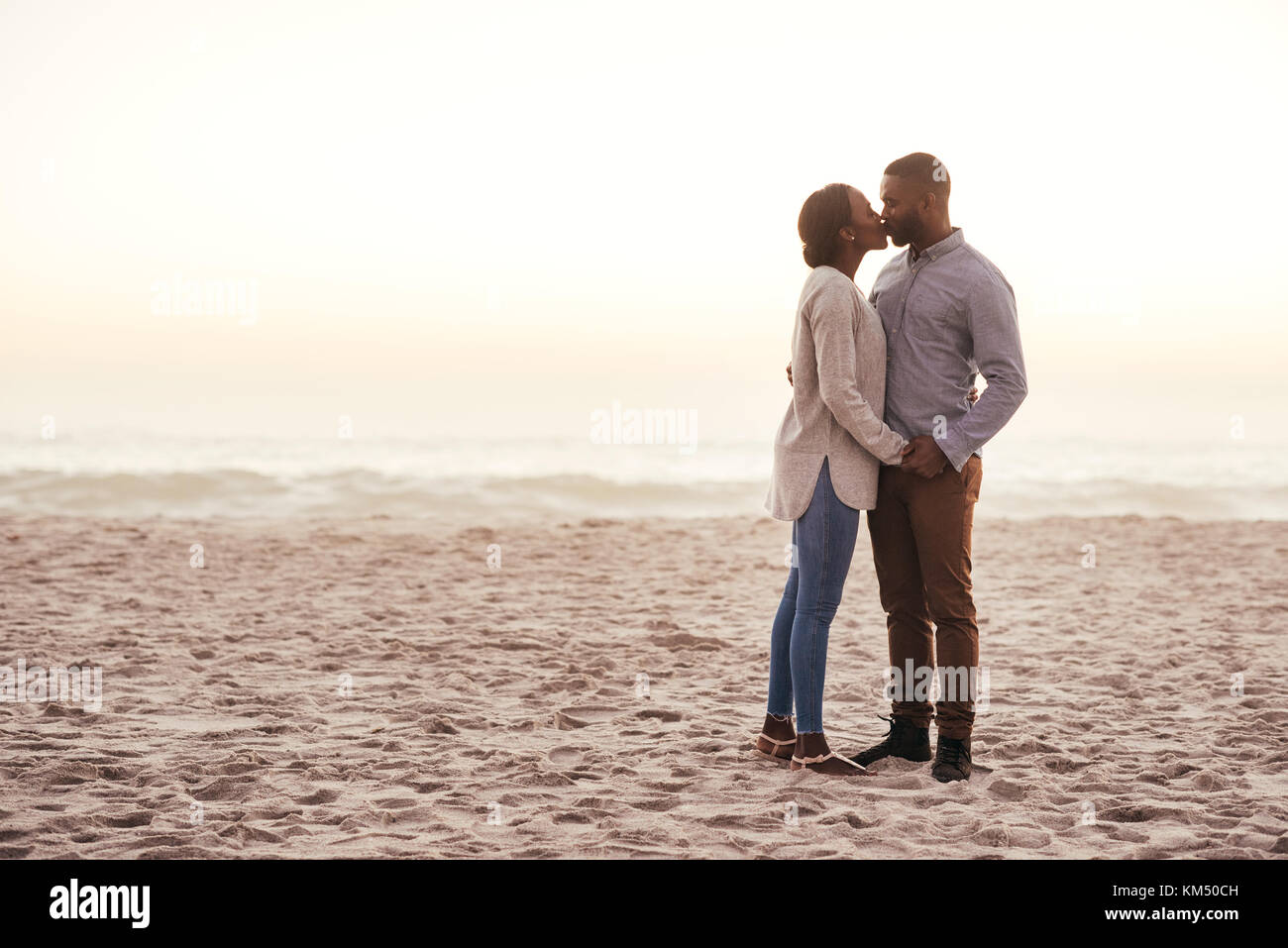 Jeune couple romantique de l'Afrique sur une plage au crépuscule Banque D'Images
