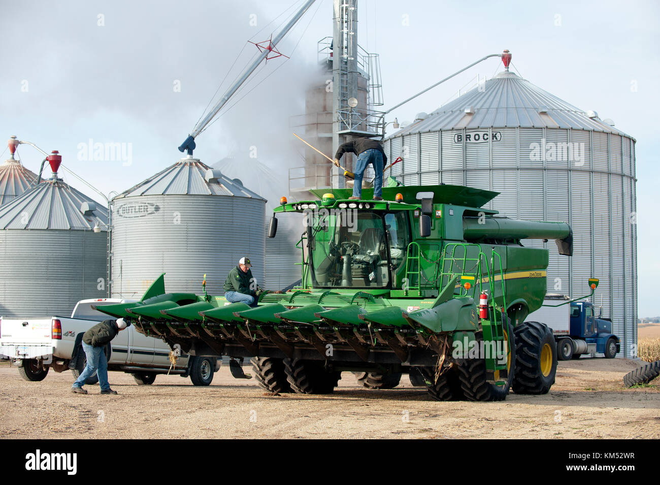 Les travailleurs et paysans NETTOYER UNE MOISSONNEUSE-BATTEUSE JOHN DEERE AVANT DE PARTIR À LA RÉCOLTE DU MAÏS SUR UNE FERME À UTICA, dans le Minnesota. Banque D'Images