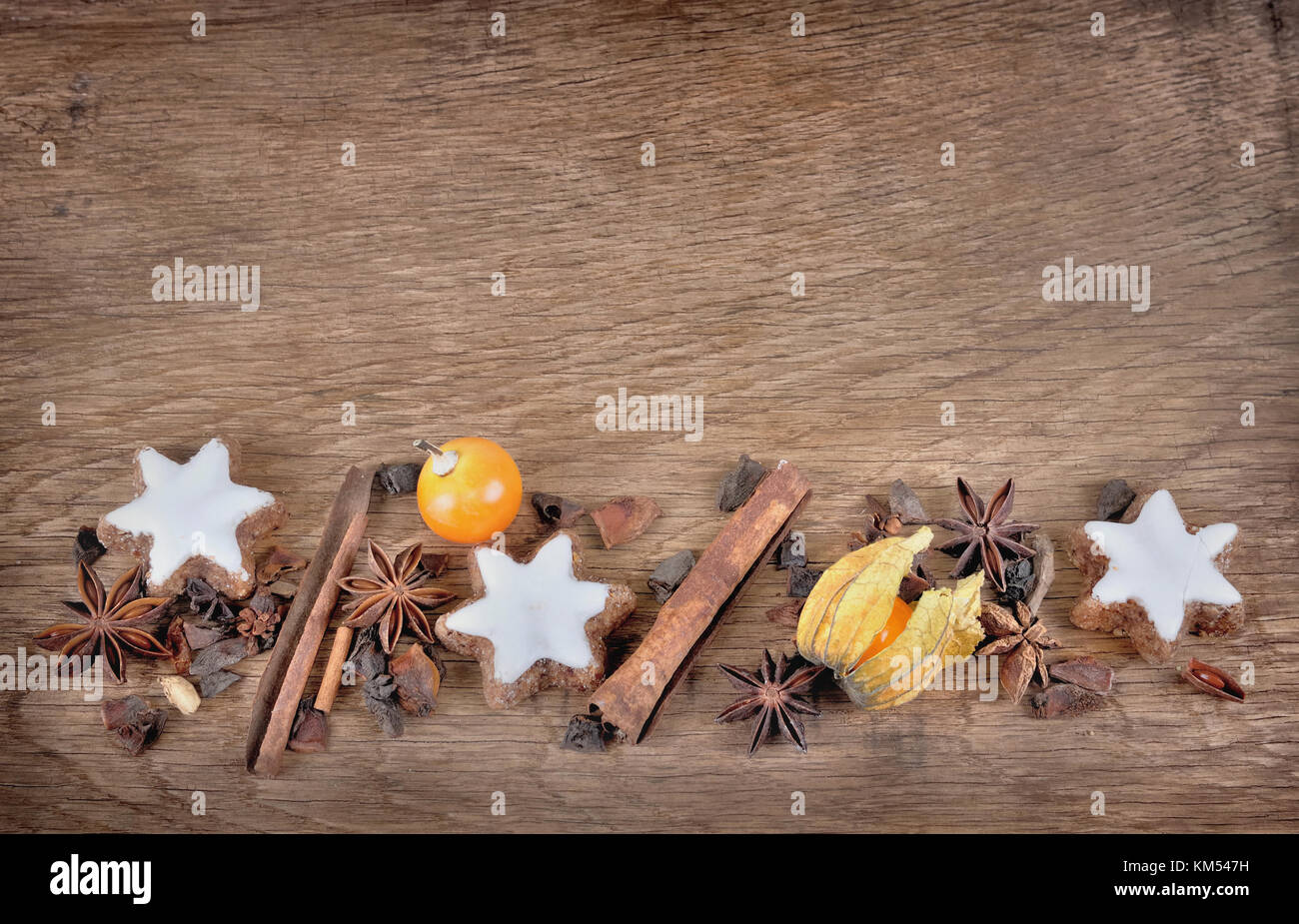 Les cookies en forme d'ÉTOILE , la cannelle, l'anis, et les fruits de physalis disposés sur une planche sur fond de bois Banque D'Images