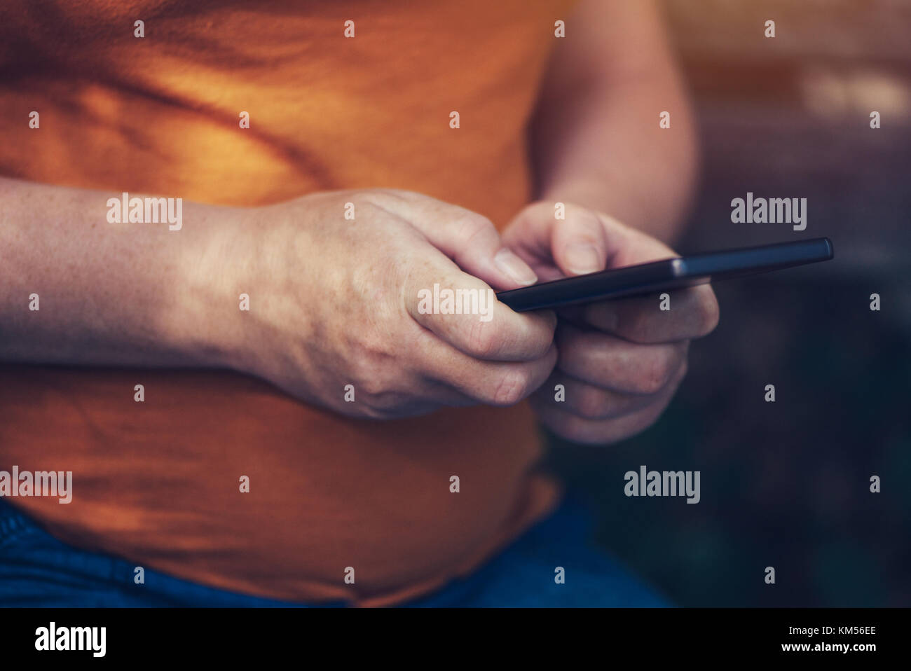 Pregnant woman texting outdoors on park bench, adulte femelle de race blanche à l'aide de téléphone mobile pendant la grossesse Banque D'Images
