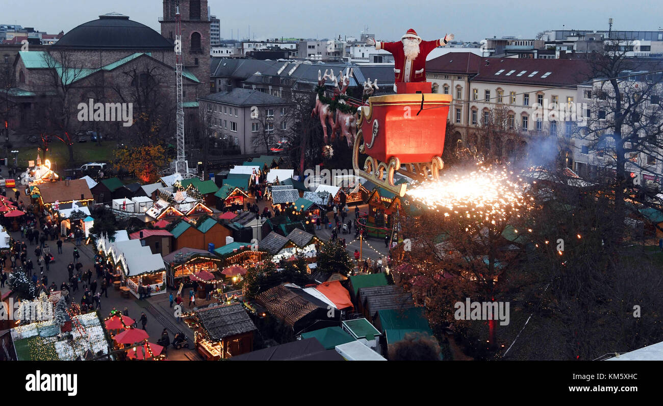 Karlsruhe, Allemagne. 5 décembre 2017. L'artiste haut-fil Falko Traber se tient debout dans un traîneau habillé en Père Noël au-dessus du marché de Noël à Karlsruhe, Allemagne, le 05 décembre 2017. Le traîneau motorisé est tiré sur une corde par des modèles de rennes deux fois par soir. Crédit : dpa Picture alliance/Alamy Live News crédit : dpa/Alamy Live News Banque D'Images