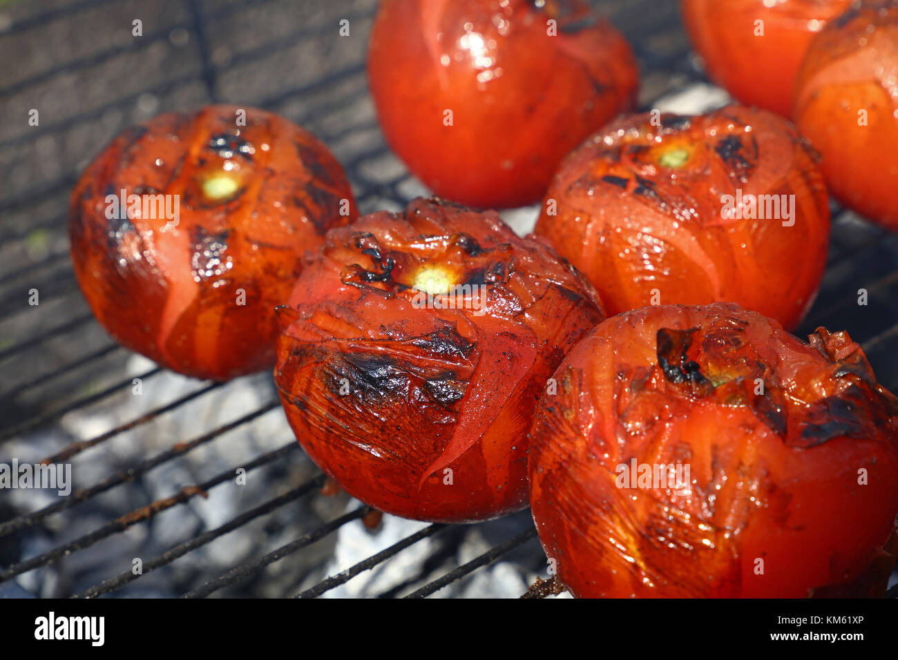 Les tomates rouges avec grillemarks la cuisson sur barbecue char avec de la fumée, Close up, high angle view Banque D'Images