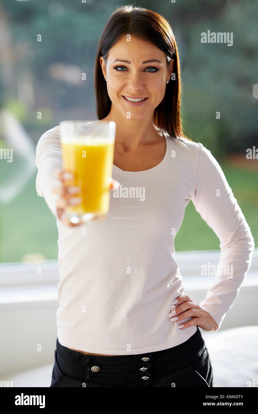 Jeune fille tenant un verre de jus d'orange Banque D'Images