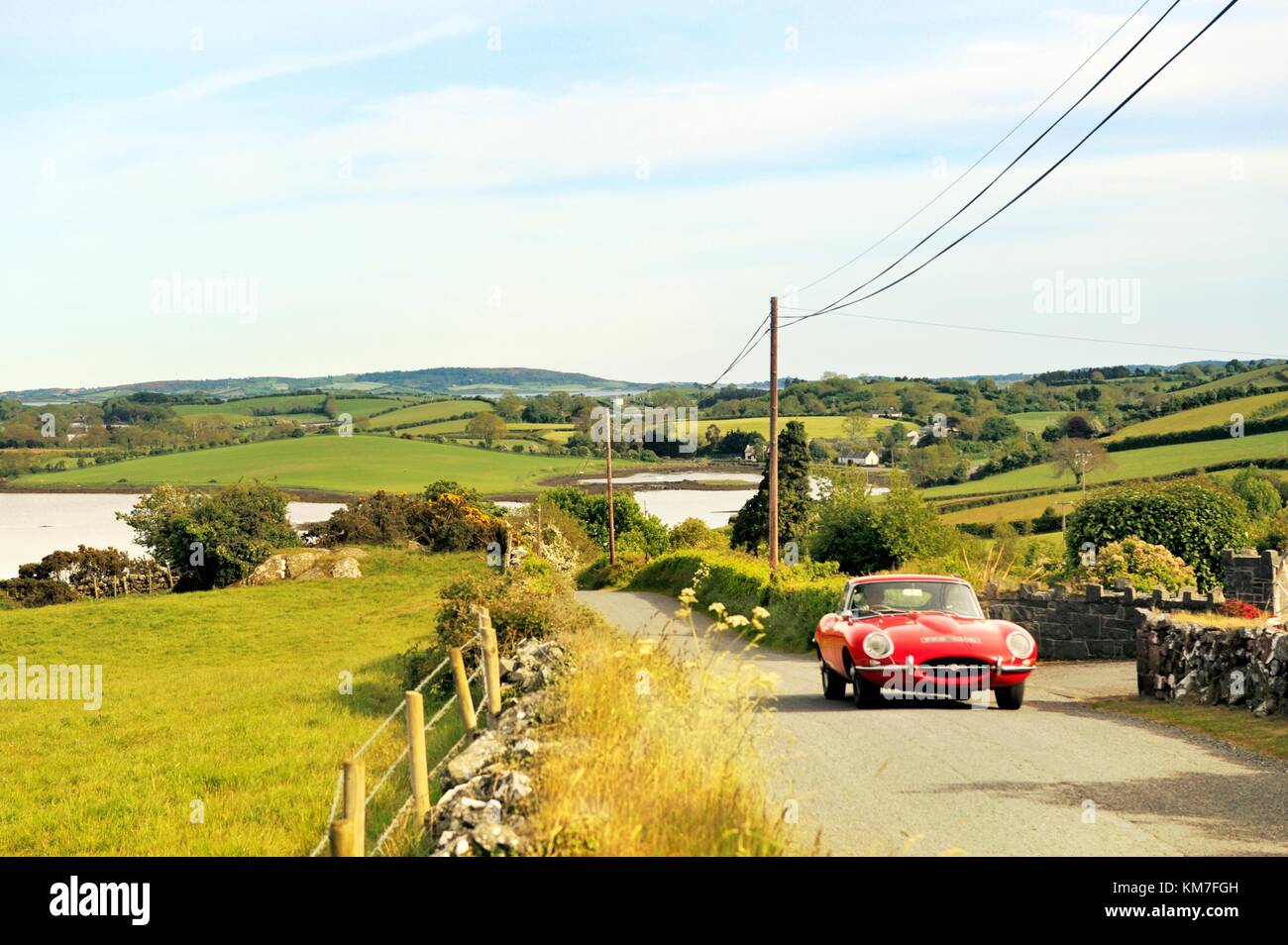 Strangford Lough à Killinchy, Co. Down, Irlande du Nord. Voiture Jaguar de type E conduisant sur la voie de campagne Banque D'Images