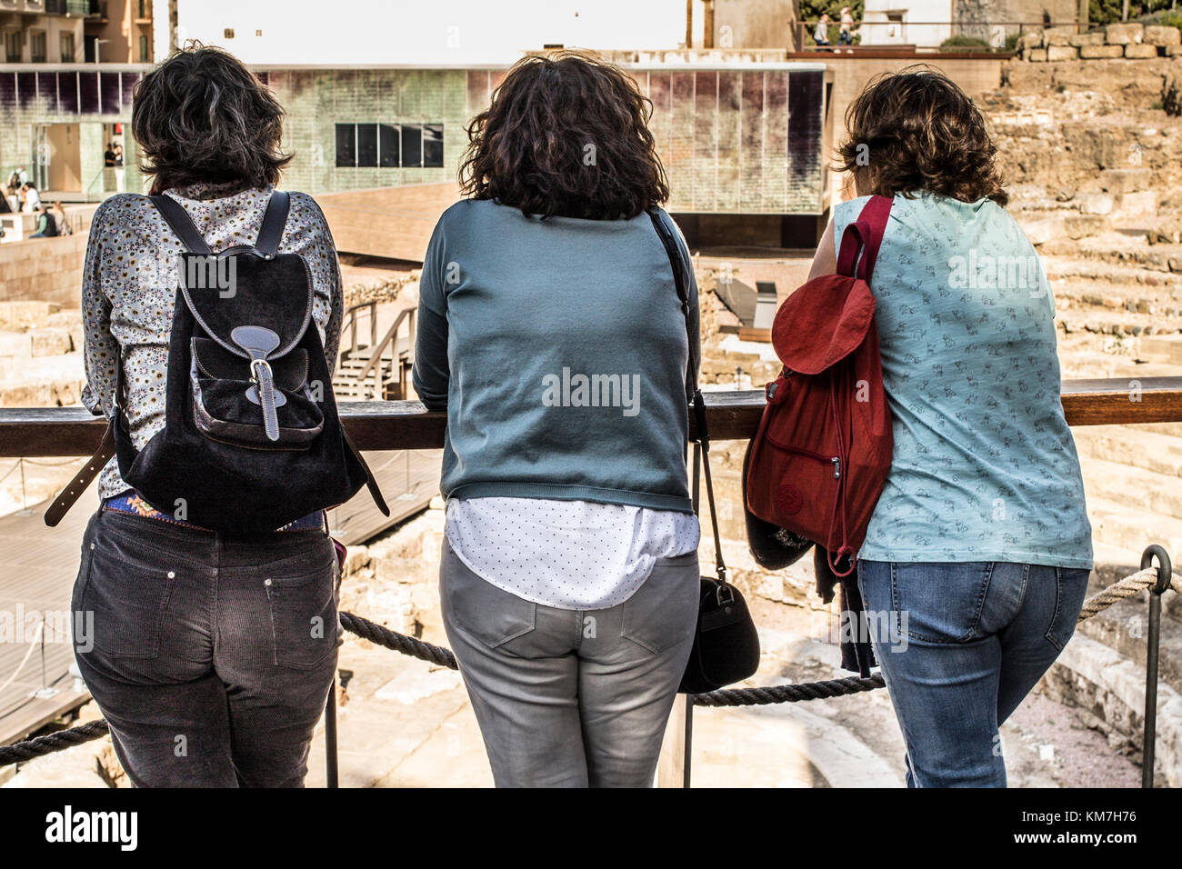 Trois femmes touristes se tenant ensemble donnant sur les amphithéâtre romain à Malaga, Espagne Banque D'Images