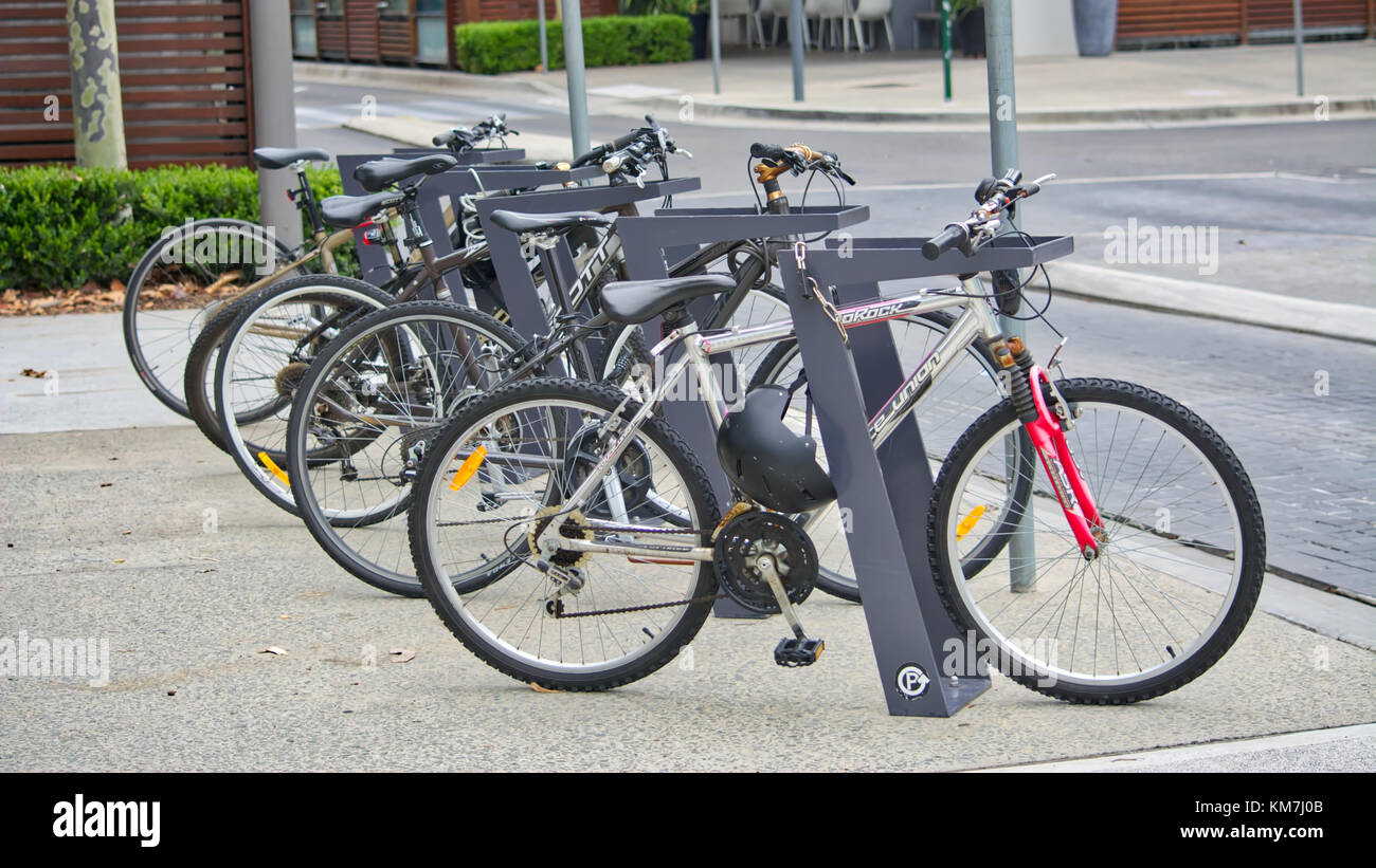 Les vélos garés à l'aire de stationnement désignée au centre commercial local. Banque D'Images