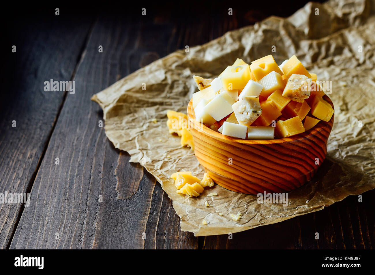 Bol en bois avec des morceaux de fromage à holland différents Banque D'Images