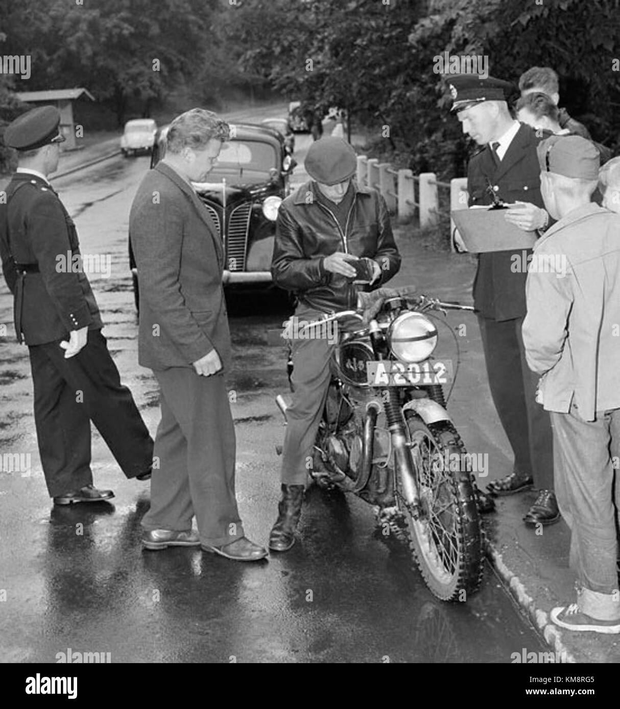 Cette image capture un poste de contrôle de la circulation à Hornsbergs Strand, Suède, en 1956. La photographie reflète le développement urbain et les systèmes de régulation de la circulation en Suède au milieu du XXe siècle. L'image offre un aperçu de la gestion du trafic en Suède pendant cette période. Banque D'Images