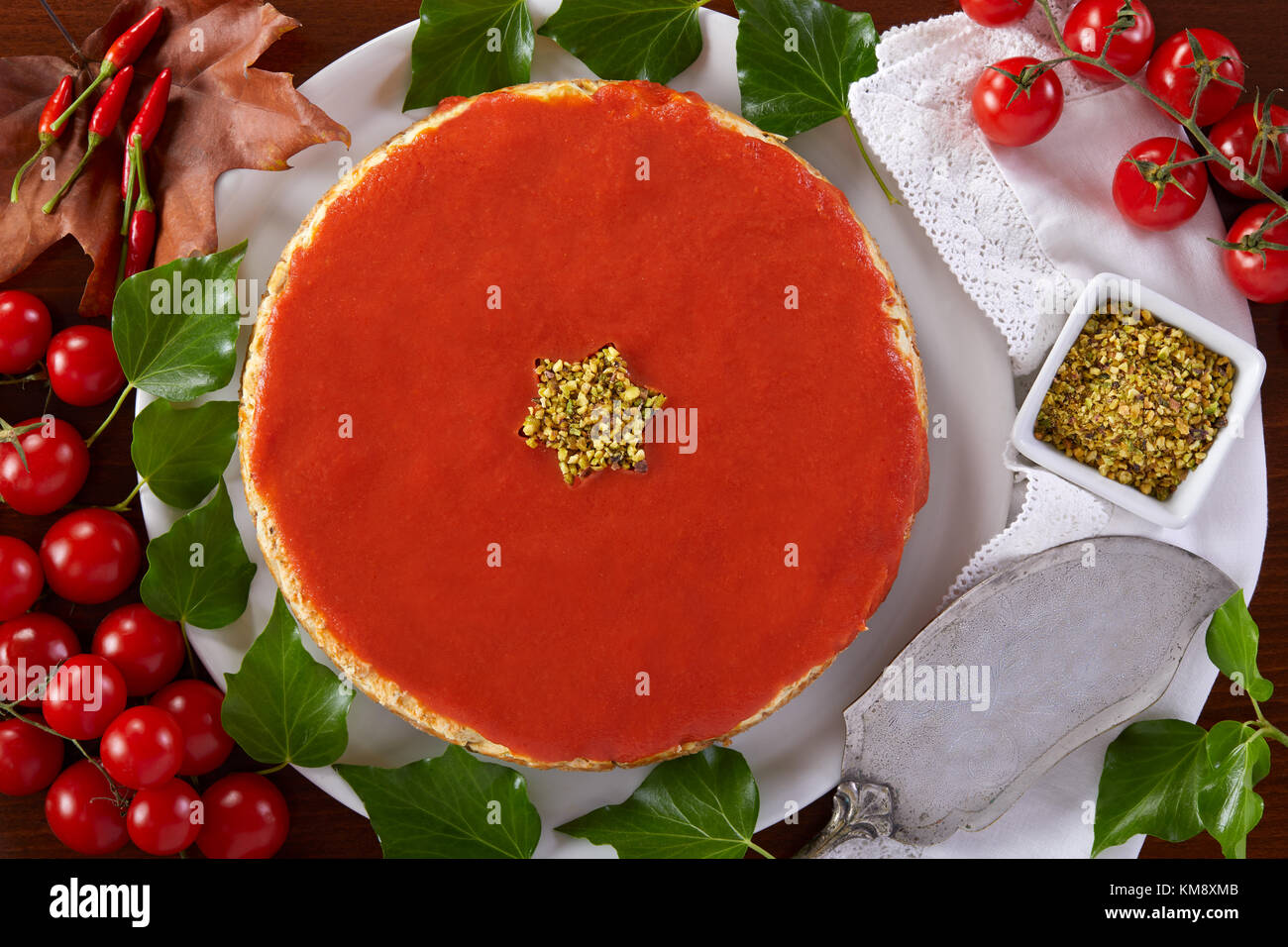 Cheesecake salé pour Noël préparé avec du fromage, de la courgette, de pistaches et de sauce tomate. Banque D'Images