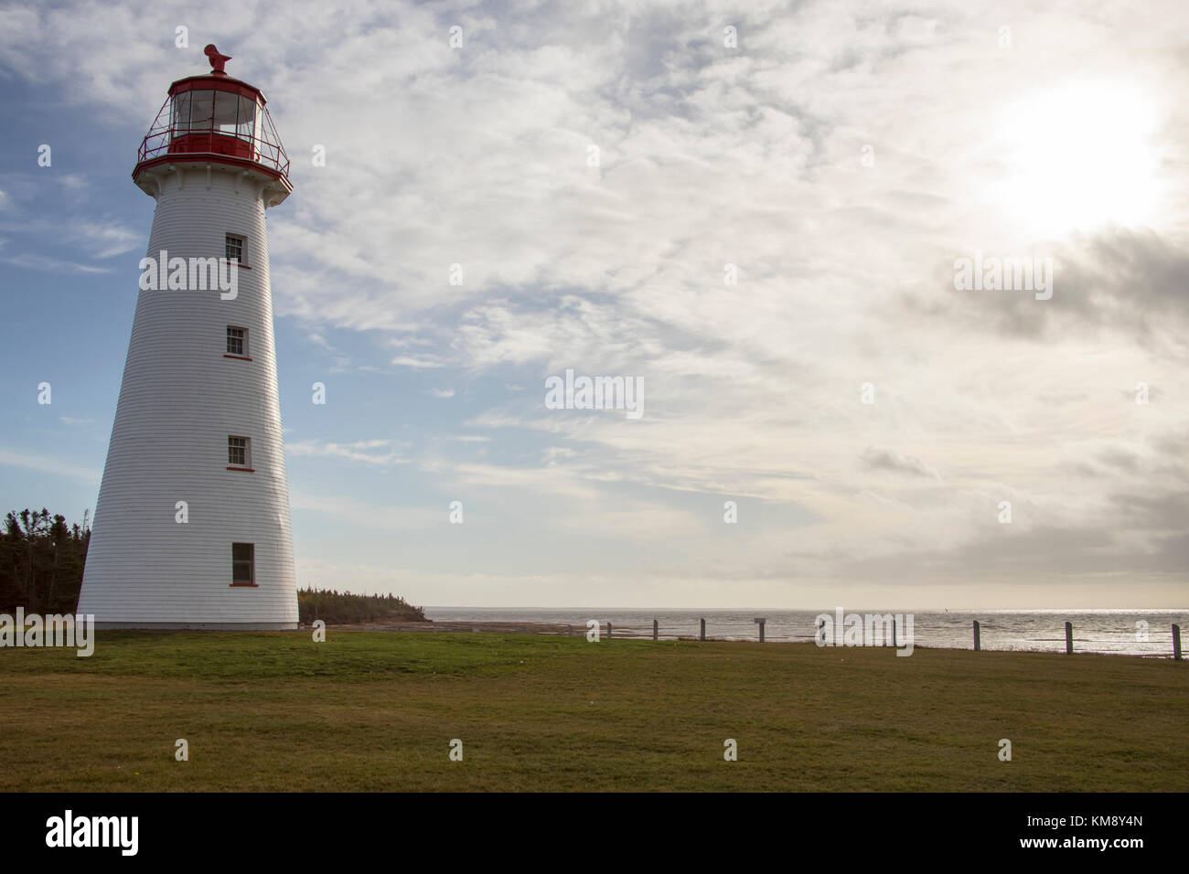 Phare de Point Prim sur l'Île du Prince Édouard, Canada contre un ciel bleu nuageux aux beaux jours. Banque D'Images