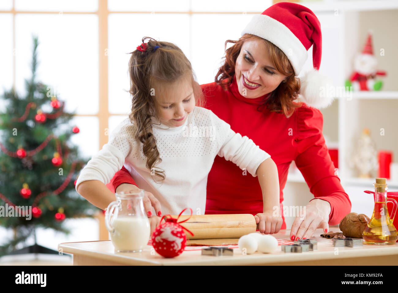 Adorable petite fille et mère baking christmas cookies Banque D'Images