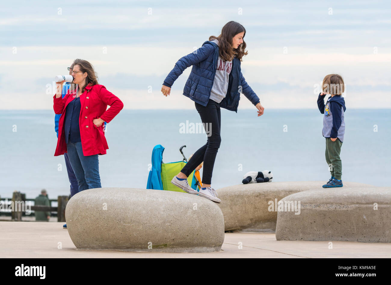 Le saut de l'enfant à travers les grosses pierres ou des rochers au bord de la mer. Banque D'Images