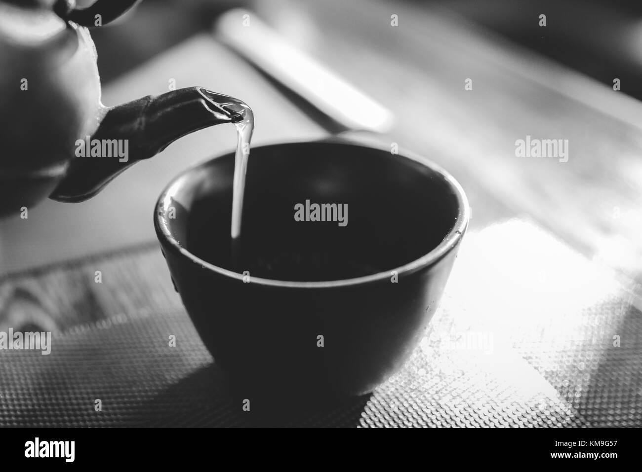 Close up de servir un thé vert japonais chaud électrique sur un style oriental cup sur table - lumière naturelle Banque D'Images