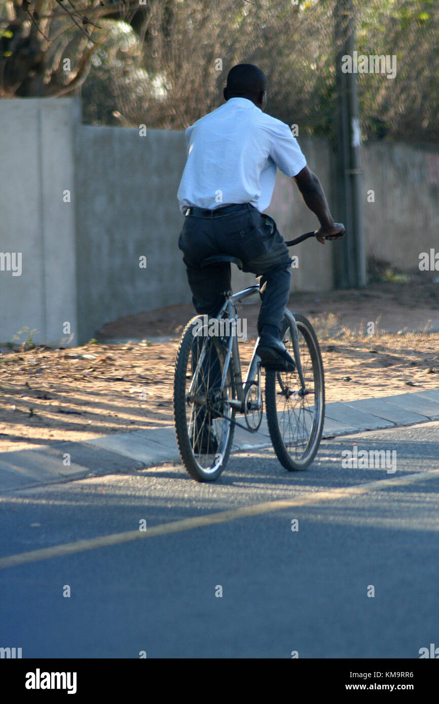 Maputo, Mozambique, l'homme de la bicyclette sur une route goudronnée Banque D'Images