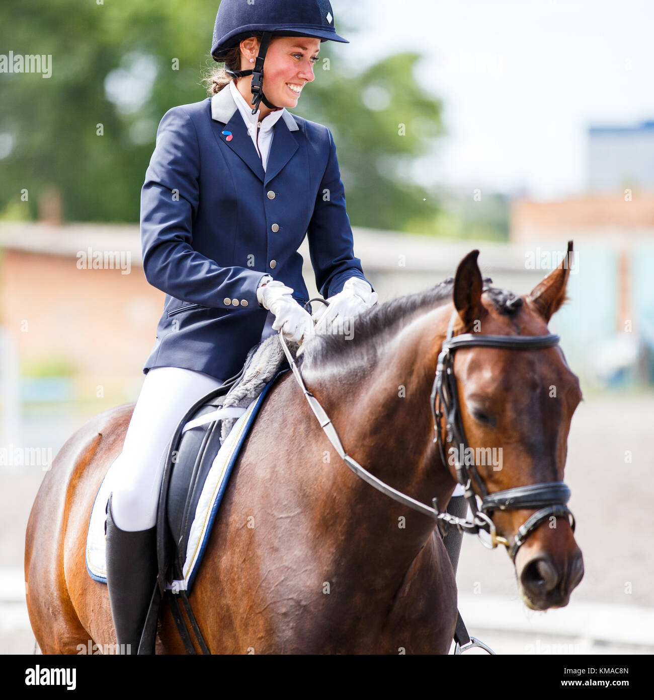 Jeune femme heureuse sur son cheval après la baie de test de dressage sur compétitions équestres Banque D'Images