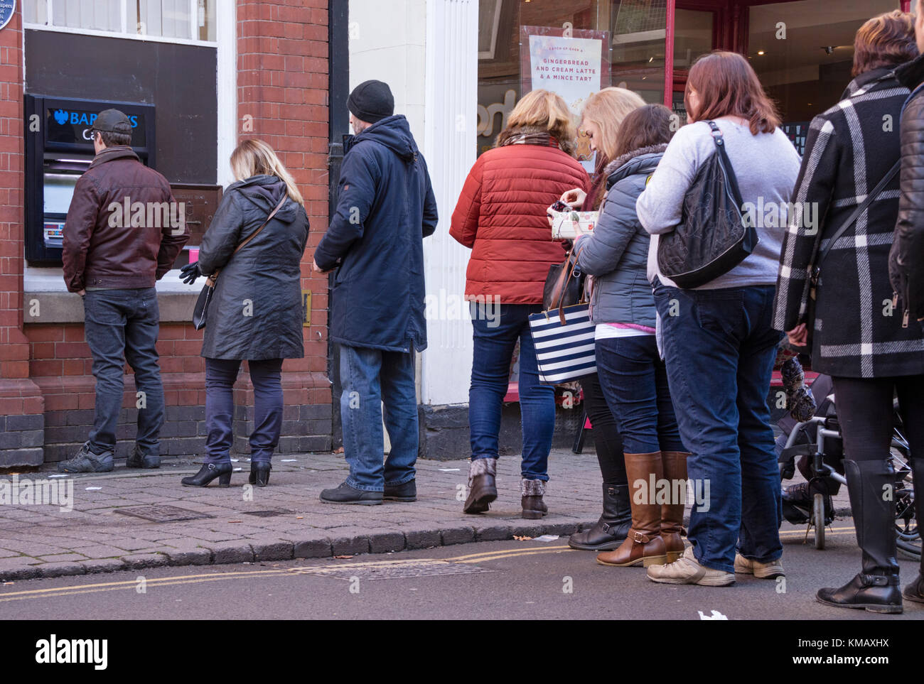 Une queue à un distributeur de billets de la rue haute, England, UK Banque D'Images