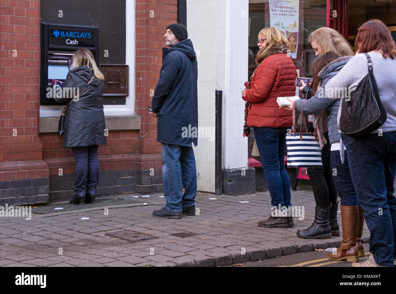 Une queue à un distributeur de billets de la rue haute, England, UK Banque D'Images
