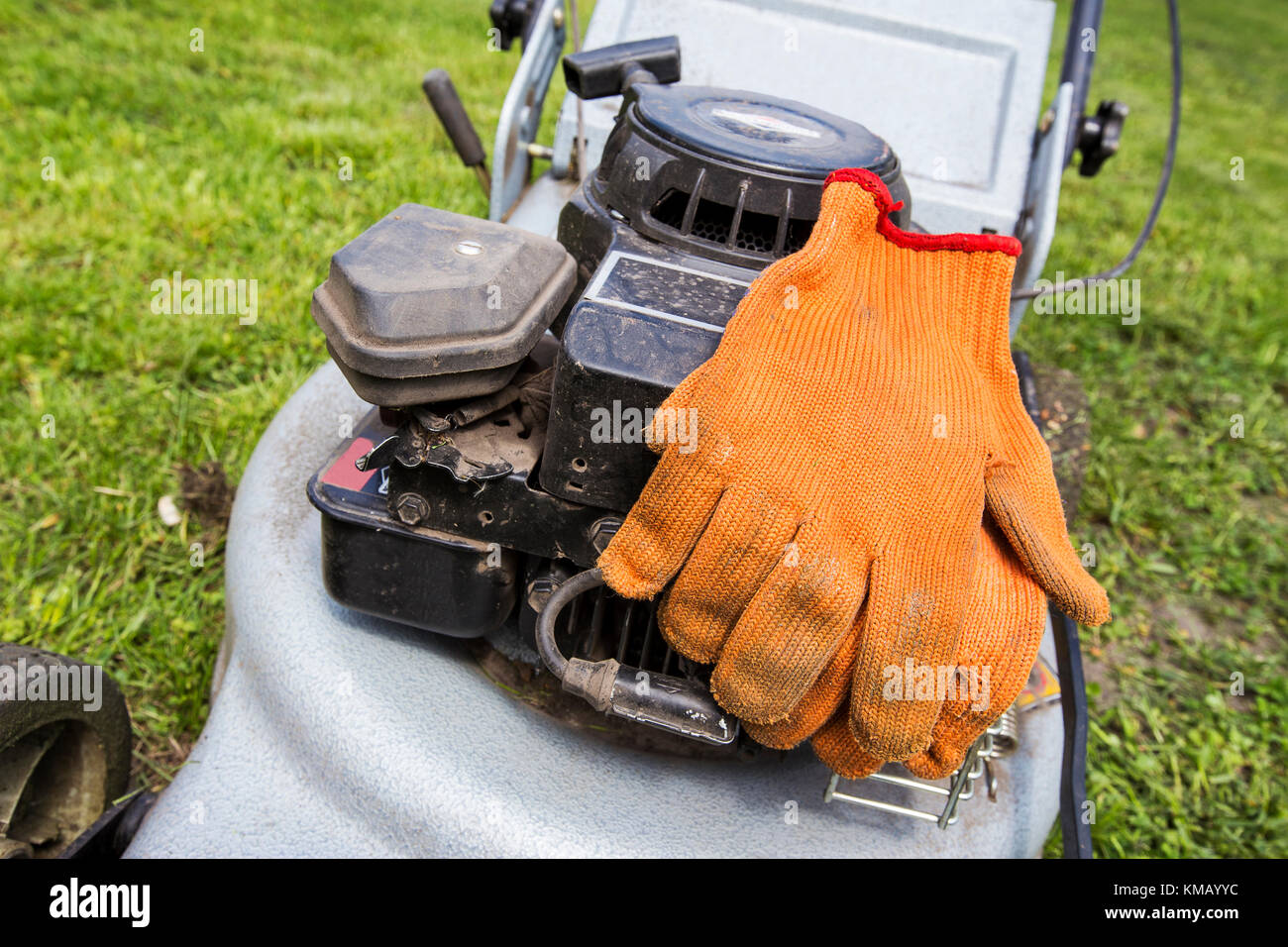 Gants orange déposer sur une tondeuse Banque D'Images