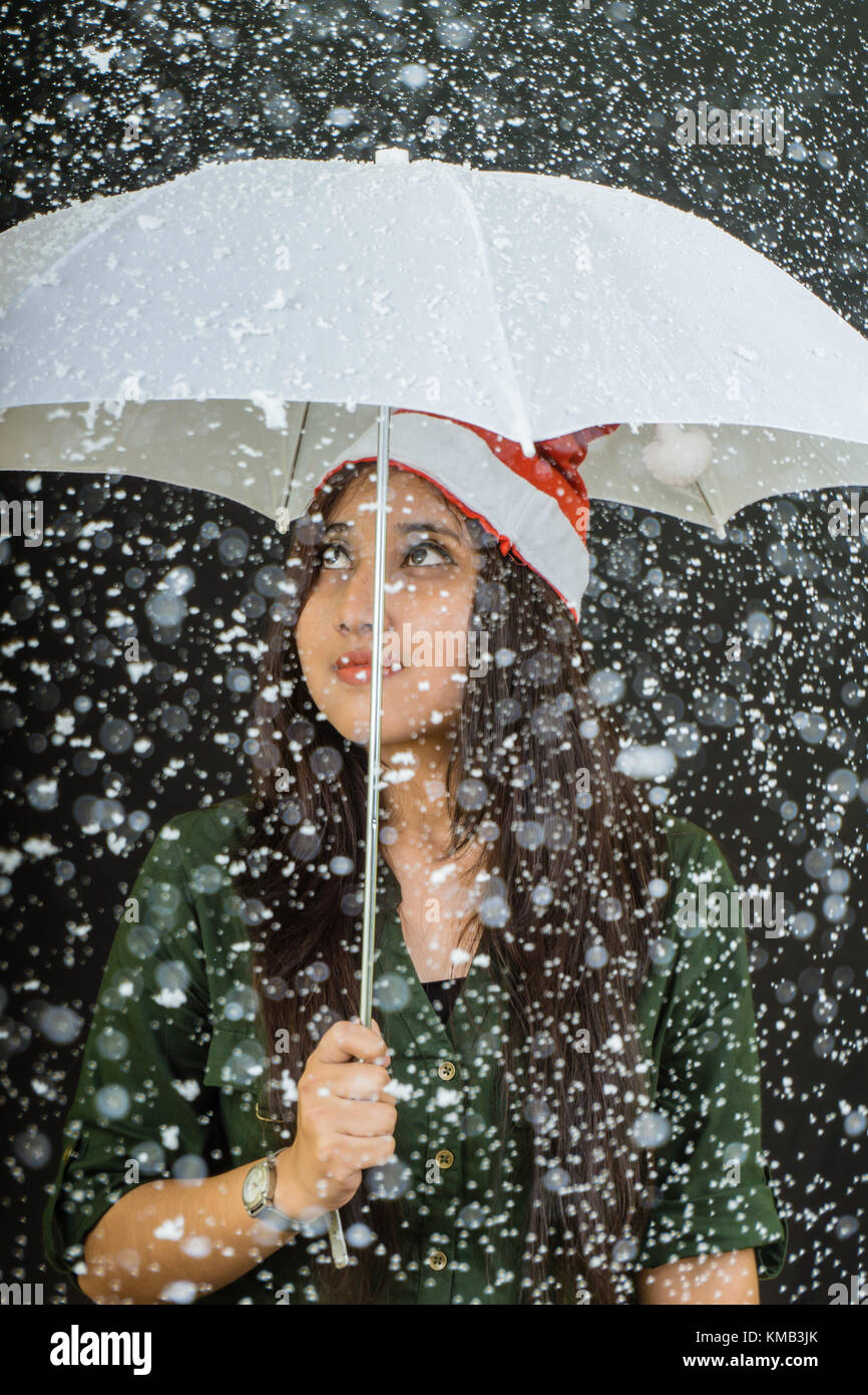 Fille avec un parapluie lors de chutes de neige. Banque D'Images