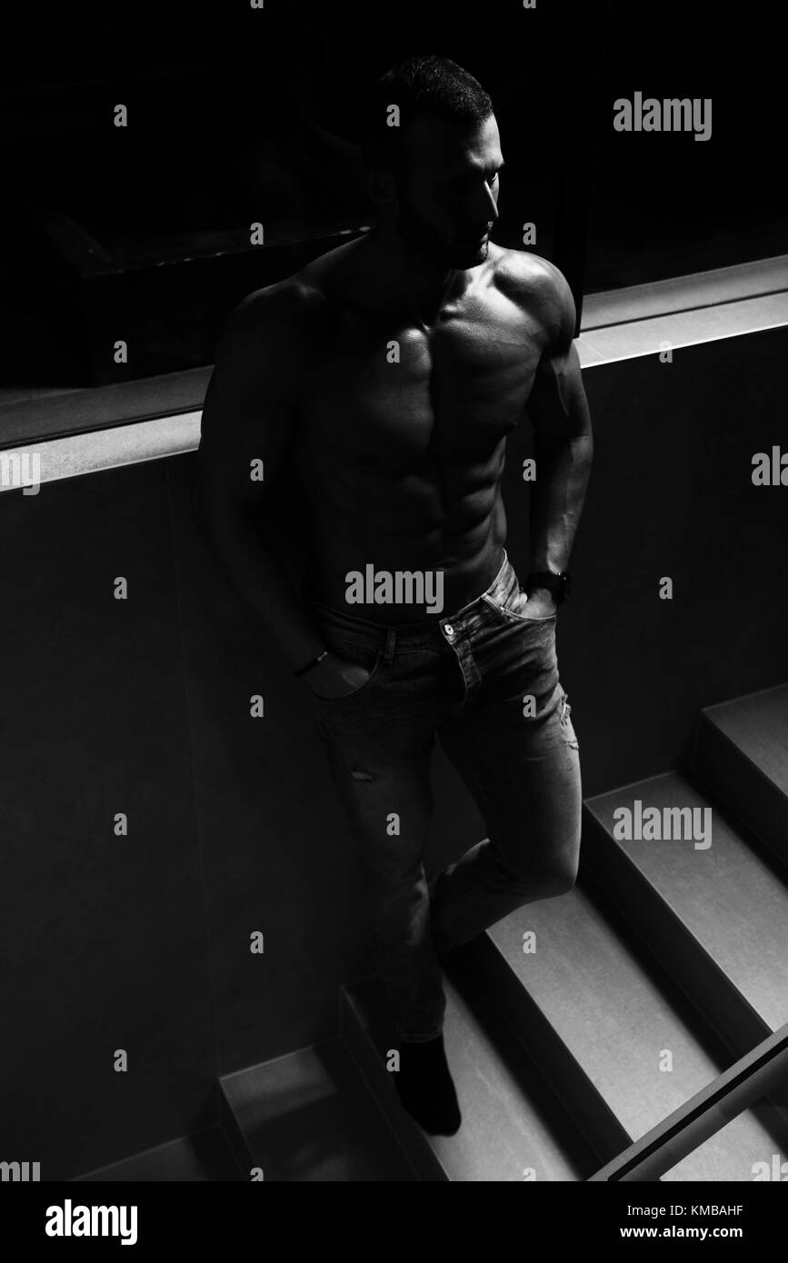 Jeune homme sain Permanent Standing Strong sur les escaliers et Flexing Muscles - Remise en forme musculaire Bodybuilder Athletic Model Posing après exercices - une Plac Banque D'Images