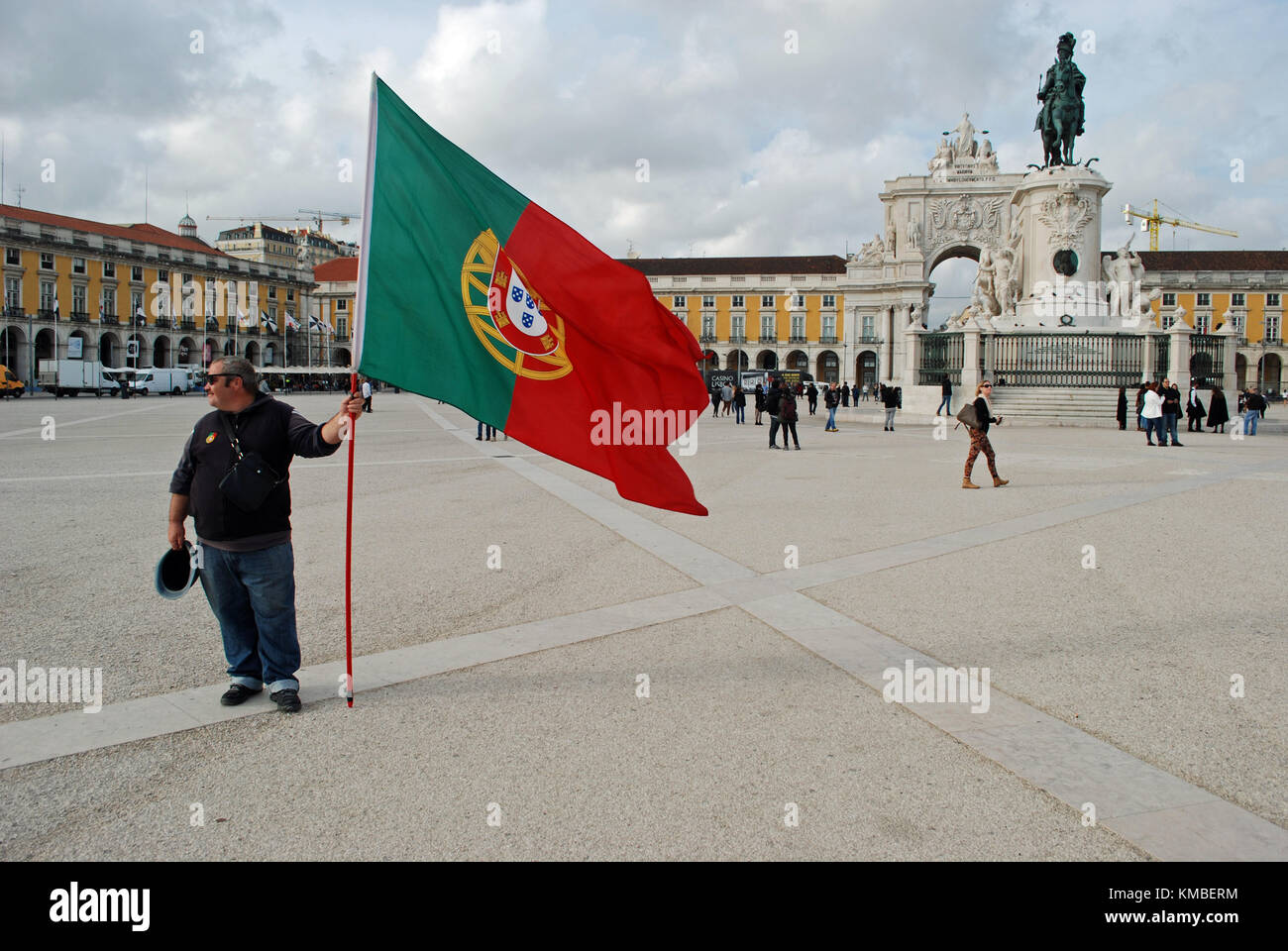 Homme battant pavillon portugais à Praça do Comércio, Lisbonne. Banque D'Images