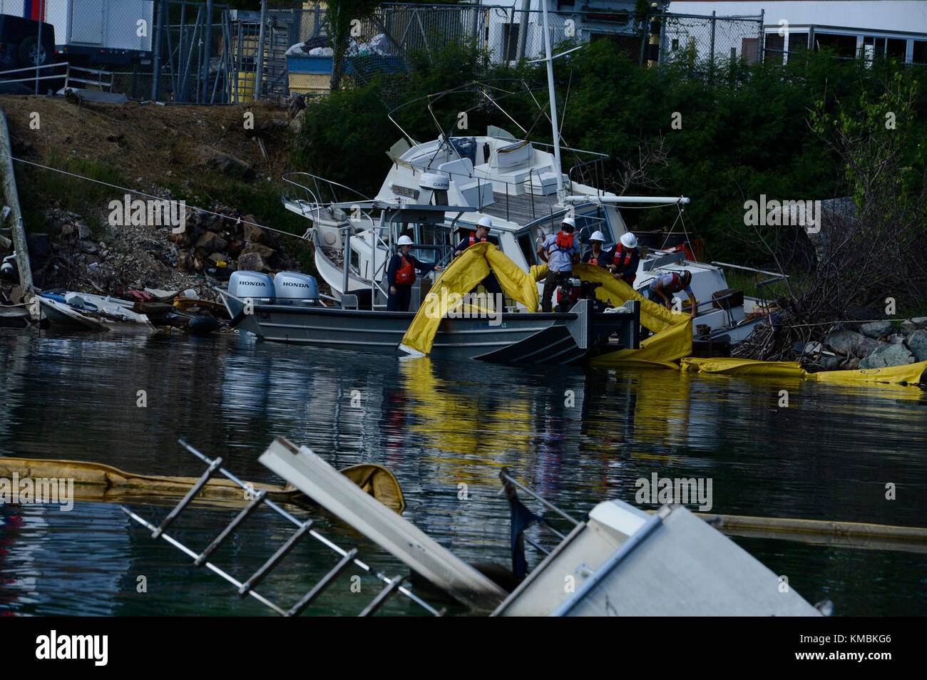 Les membres de la Garde côtière et un entrepreneur de l'Agence de protection de l'environnement supervisent le personnel de Resolve Marine Group, une société d'intervention sous contrat, alors qu'ils s'embarque d'un navire abandonné à Krum Bay dans le cadre de la mission et des opérations de la fonction de soutien d'urgence 10 à St. Thomas, le 2 décembre 2017. La Garde côtière et l'EPA coordonnent les opérations d'intervention du FSE-10 afin d'assurer la sécurité du personnel et la protection de l'environnement. Garde-côtes Banque D'Images