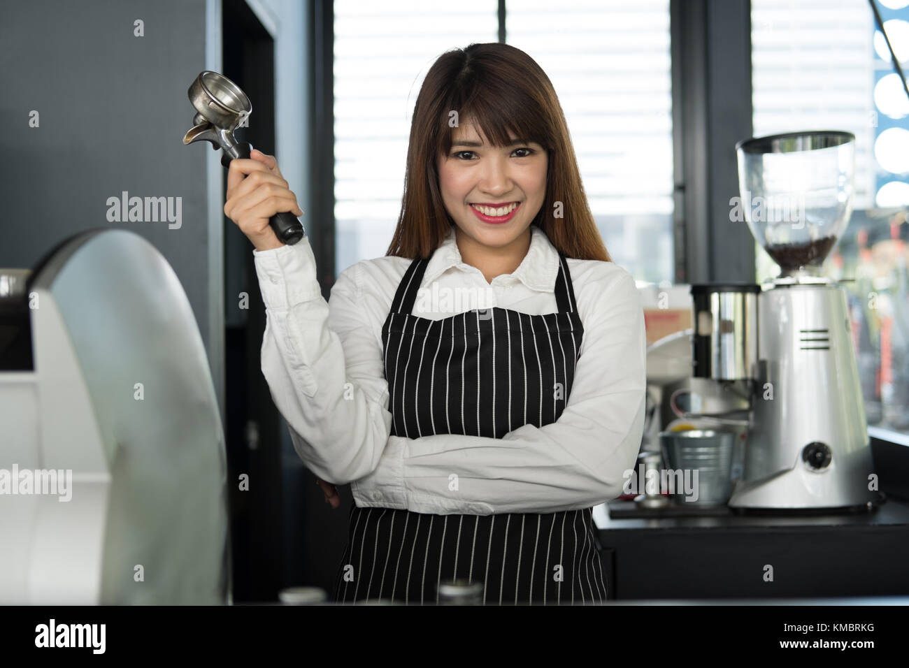 Small business owner standing at counter in coffee shop. asian female barista portant un tablier smiling at bar à café. food service, concept de restaurant. Banque D'Images
