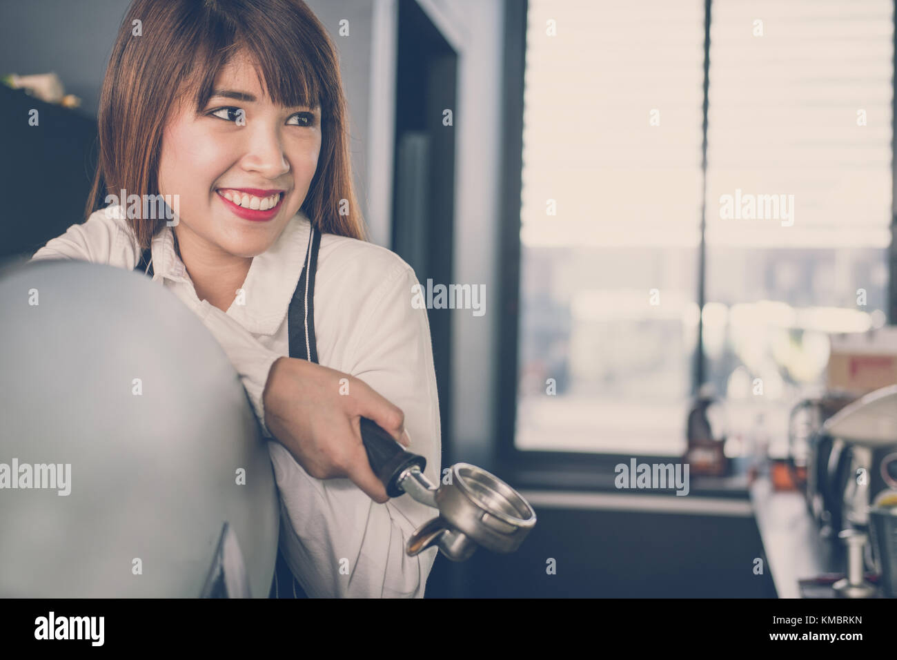 Small business owner standing at counter in coffee shop. asian female barista portant un tablier smiling at bar à café. food service, concept de restaurant. Banque D'Images
