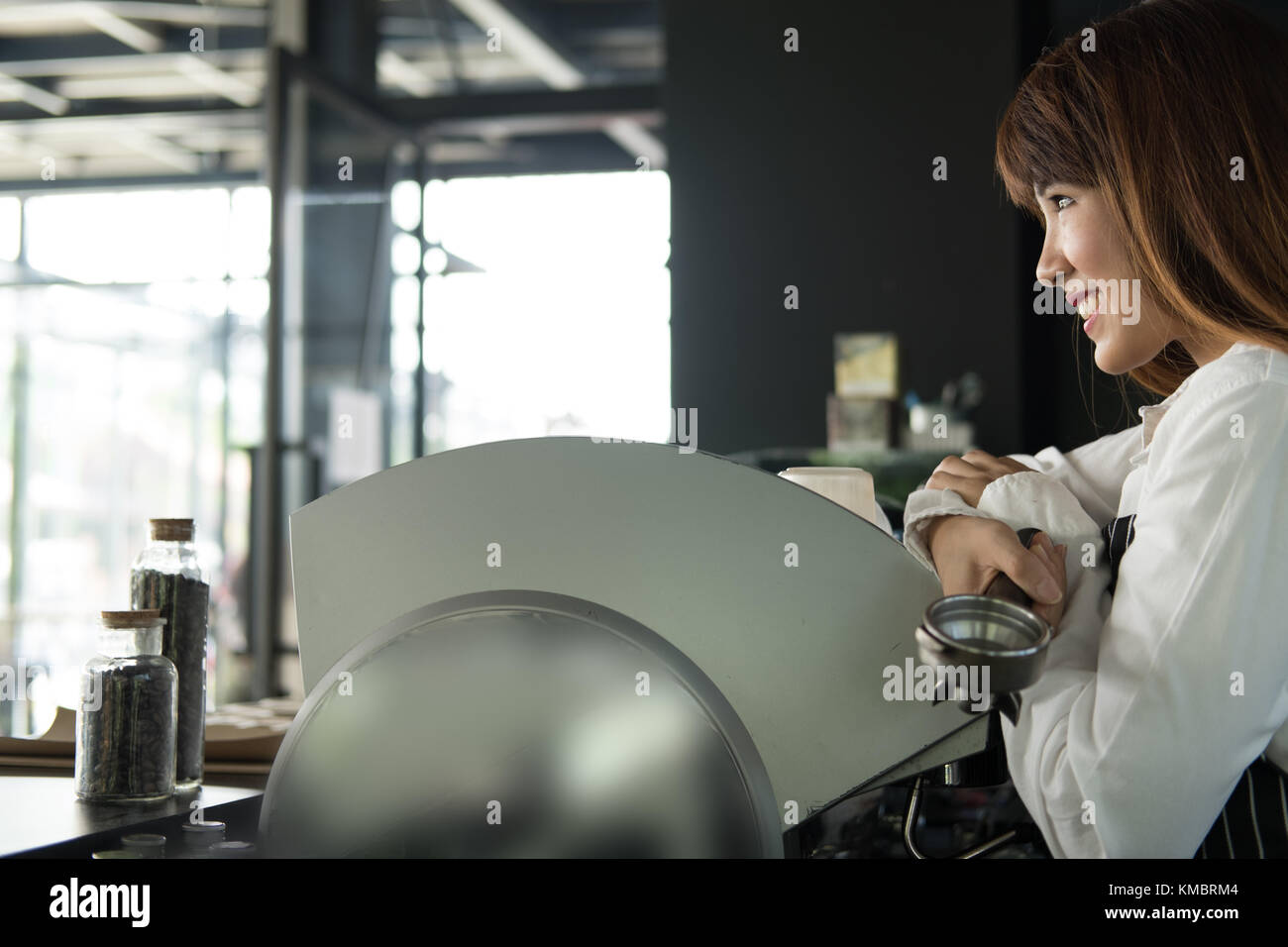 Small business owner standing at counter in coffee shop. asian female barista portant un tablier smiling at bar à café. food service, concept de restaurant. Banque D'Images