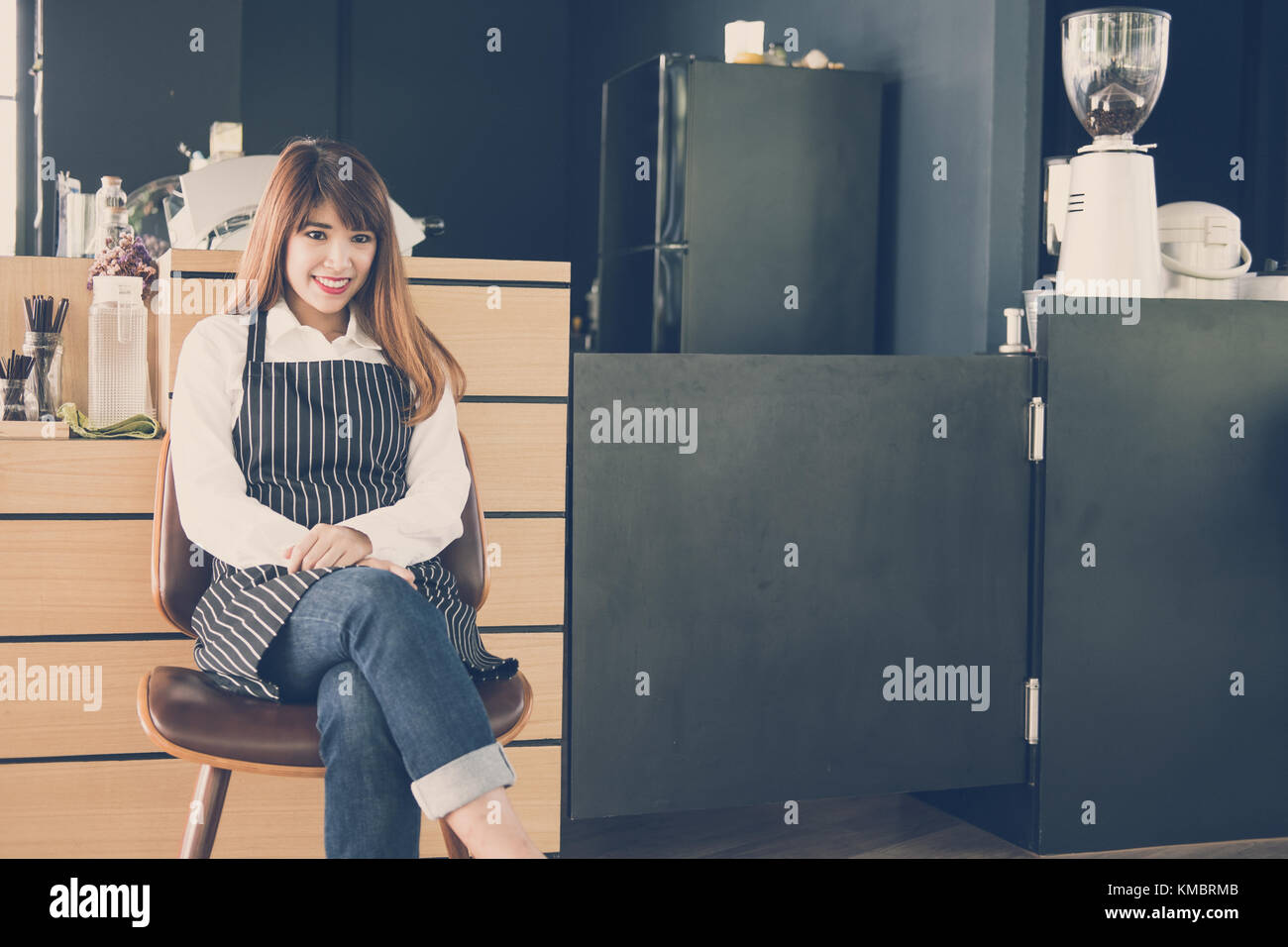 Propriétaire de petite entreprise assis au comptoir à café. asian female barista portant un tablier smiling at bar à café. food service, concept de restaurant. Banque D'Images