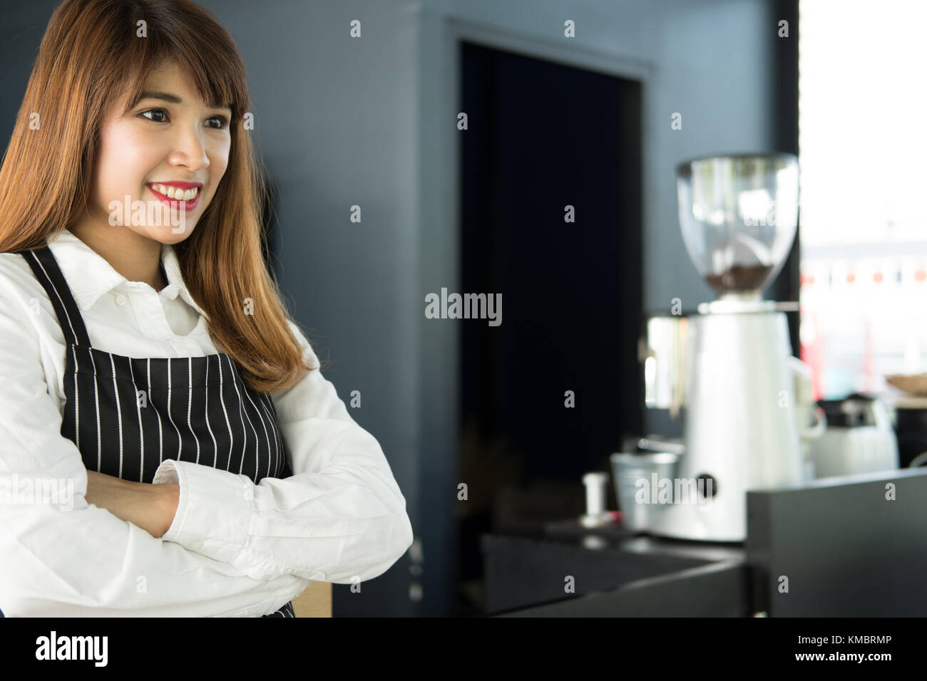 Small business owner standing at counter in coffee shop. asian female barista portant un tablier smiling at bar à café. food service, concept de restaurant. Banque D'Images