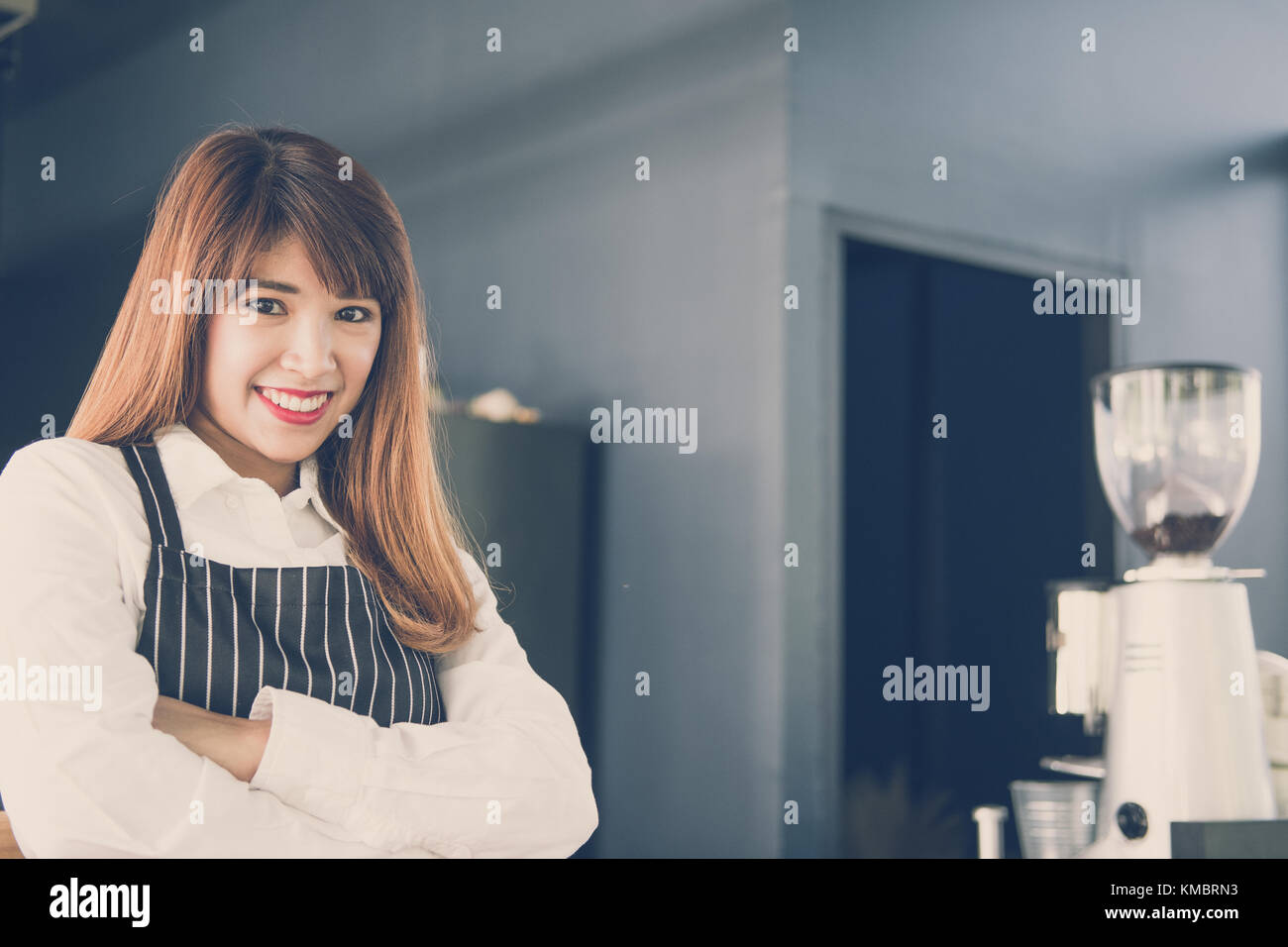 Small business owner standing at counter in coffee shop. asian female barista portant un tablier smiling at bar à café. food service, concept de restaurant. Banque D'Images