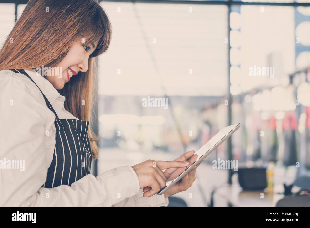 Propriétaire de petite entreprise holding tablet in coffee shop. asian female barista de porter un tablier à l'aide au touchpad dans bar cafe. service alimentaire, restaur Banque D'Images