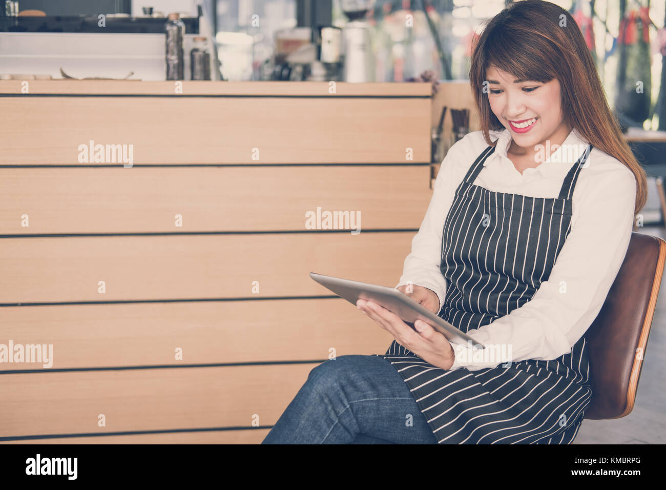 Propriétaire de petite entreprise holding tablet in coffee shop. asian female barista de porter un tablier à l'aide au touchpad dans bar cafe. service alimentaire, restaur Banque D'Images
