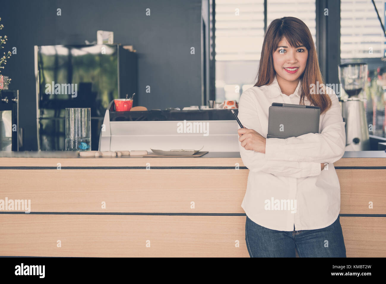 Propriétaire de petite entreprise holding notebook au comptoir à café. asian female barista standing at bar à café. food service, concept de restaurant. Banque D'Images