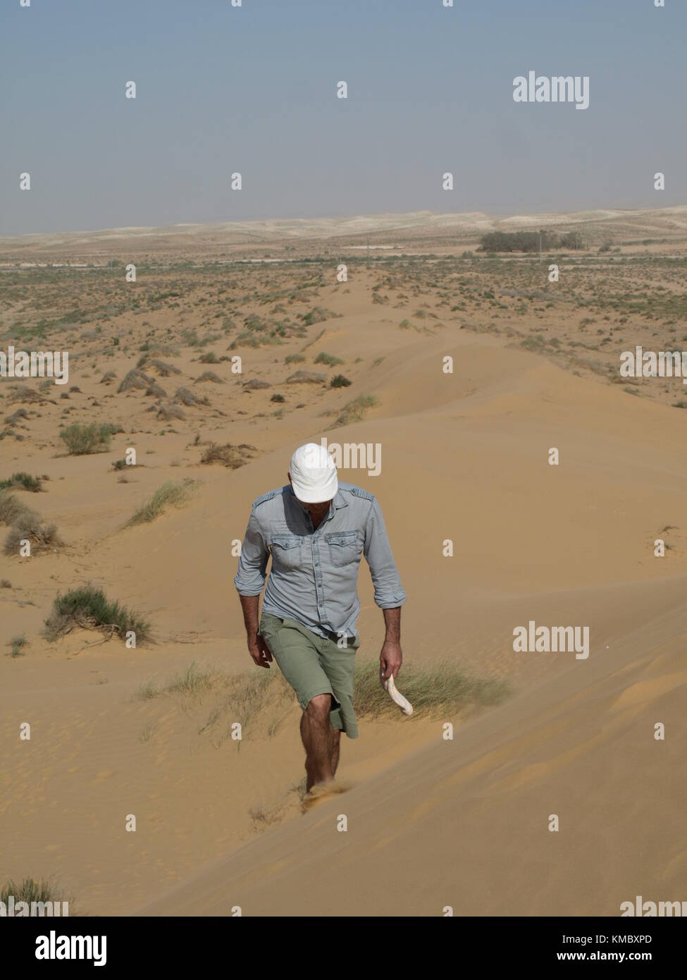 Un homme marchant dans le désert sur une dune de sable Banque D'Images